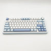 A light blue mechanical gaming keyboard with a full layout and customizable keycaps is shown on a white background.