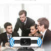 A black 4K auto-focus streaming webcam with a microphone is shown in front of three people.
