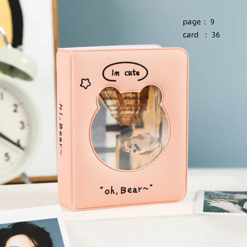 A pink hollow photo card binder with a bear face cutout and text on the front
