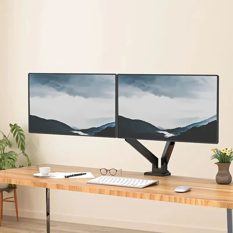 A dual monitor setup featuring two screens displaying a misty landscape, mounted on an ergonomic black adjustable arm.