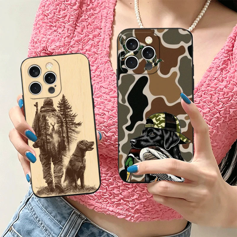 A hand holds a phone case featuring a hunting dog design on a patterned background, worn over a pink textured top.