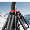 A black Open4-legged tripod is set up in the snow, showing its structure and legs.