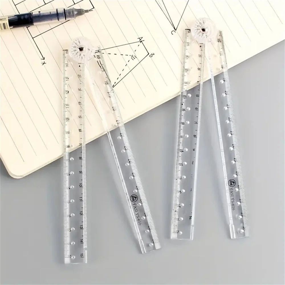 A set of precision acrylic folding rulers and a black pen are displayed on lined paper.