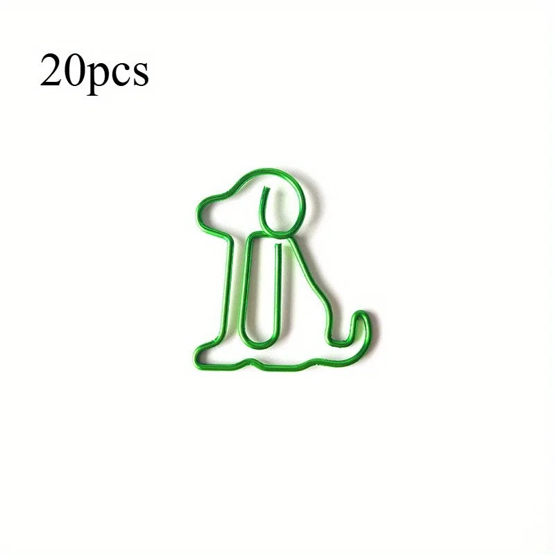 A single green paper clip shaped like a sitting dog, used as a cute desk organizer.