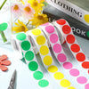 Rolls of round dot labels in assorted colors pink yellow and green for organization
