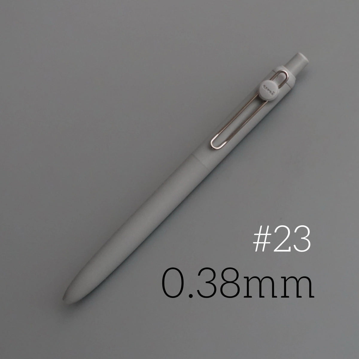 A close-up view of a light gray precision gel pen with a silver clip and a 0.38mm tip.