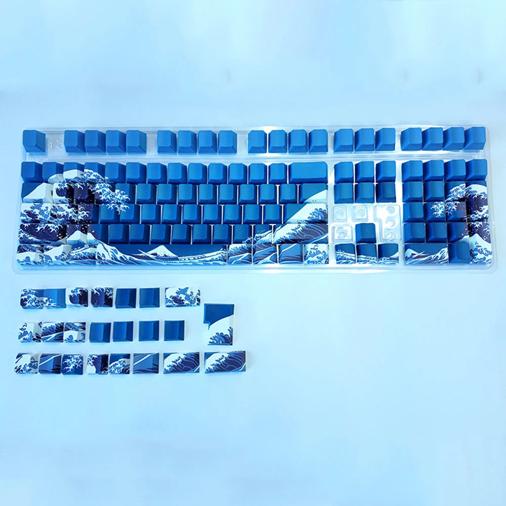 A set of translucent blue Ukiyo-e keycaps for a mechanical keyboard, featuring mountain and landscape designs.