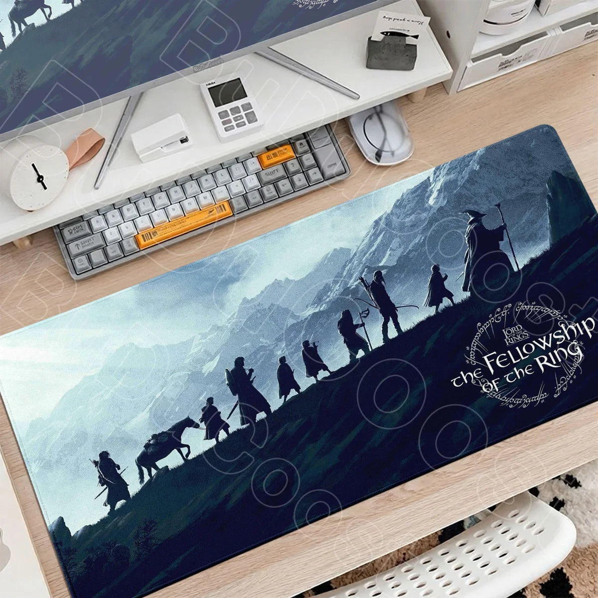 A large gaming mouse pad featuring a dark landscape with figures from Lord of the Rings and circular designs.
