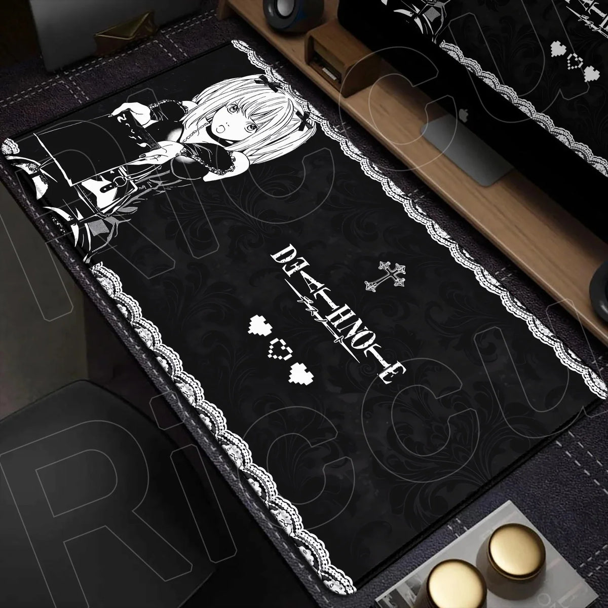 A black mouse pad featuring a Death Note character illustration and a decorative border on a wooden desk surface.
