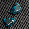 A pair of blue transparent in-ear monitors with a black housing and ZERO:2 branding resting on a dark textured surface.
