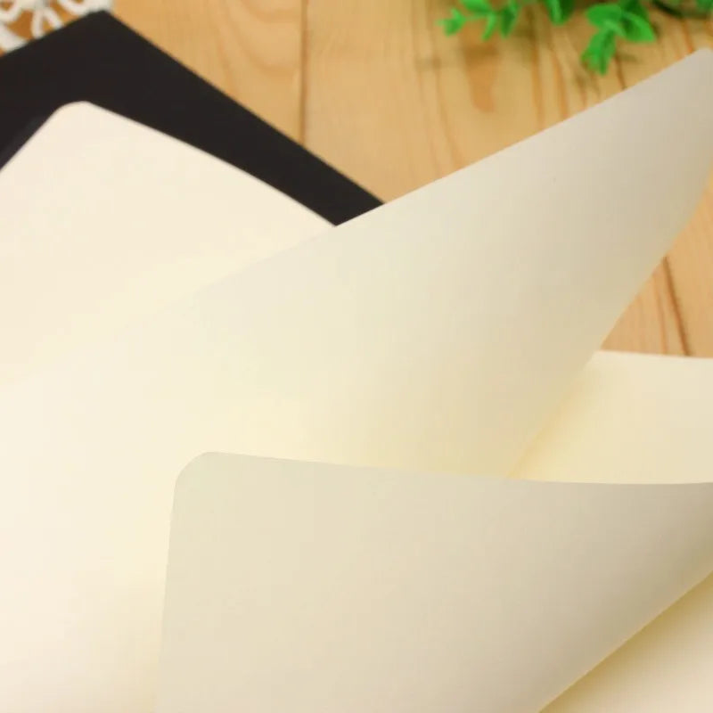 A white A6 blank sketchbook is shown angled on a wooden surface.