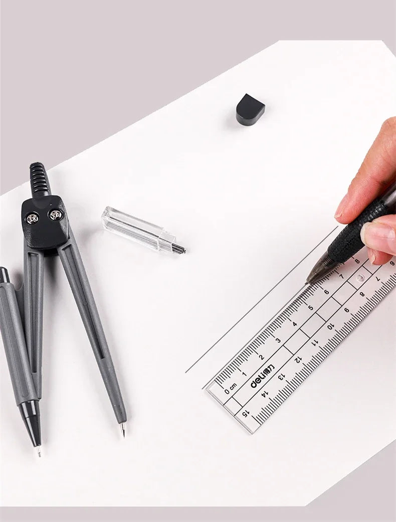 A hand holds a black pen over a ruler on white paper next to various drafting tools including a mechanical pencil and a small