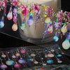 A roll of decorative PET washi tape featuring colorful, iridescent, and floral-themed charms.