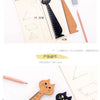 A set of cute cartoon cat wooden drawing rulers and pencils shown next to a sheet of paper.