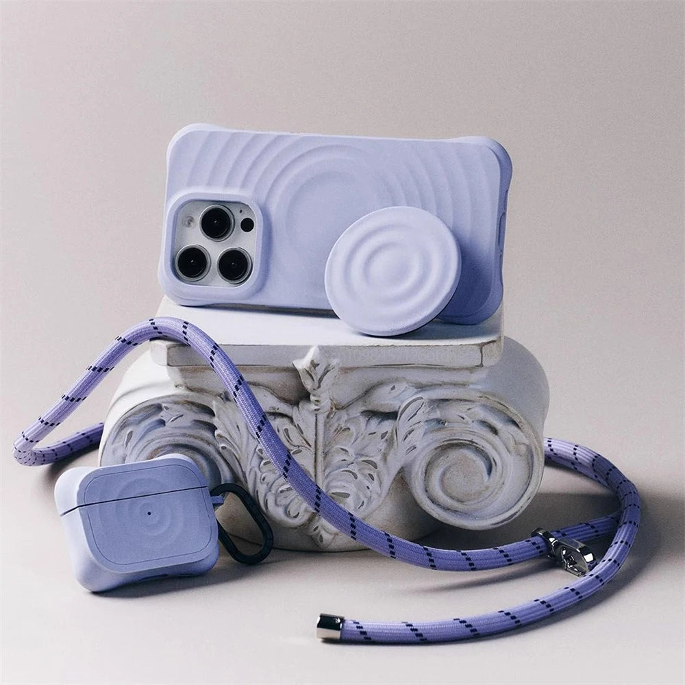 A light blue silicone Ripple Grip magnetic phone stand with a purple cord resting on a white decorative base.