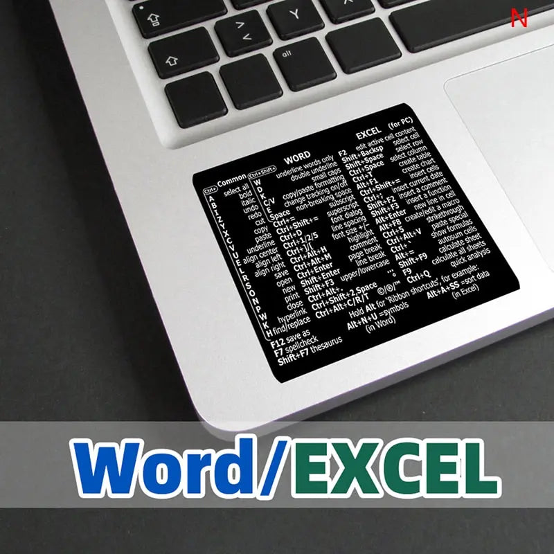 A close-up view of a laptop keyboard showing a Word/Excel shortcut reference chart.