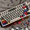 Nahaufnahme einer maßgefertigten mechanischen Cherry-Tastatur mit farbigen Keycaps auf einer Holzoberfläche.