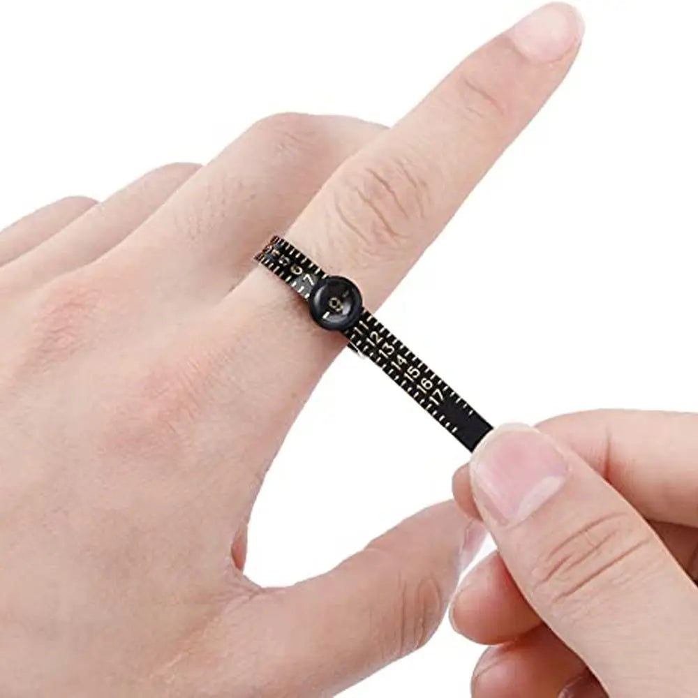 A hand is holding a black precision ring sizer and gauge tool, showing its measurement markings.