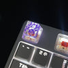 A close-up view of translucent purple botanical resin keycaps resting on a mechanical keyboard switch housing.