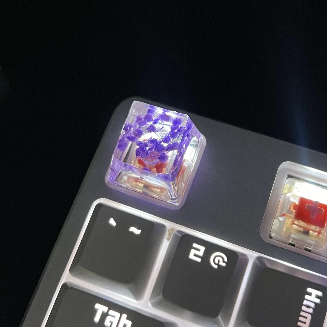 A close-up view of translucent purple botanical resin keycaps resting on a mechanical keyboard switch housing.