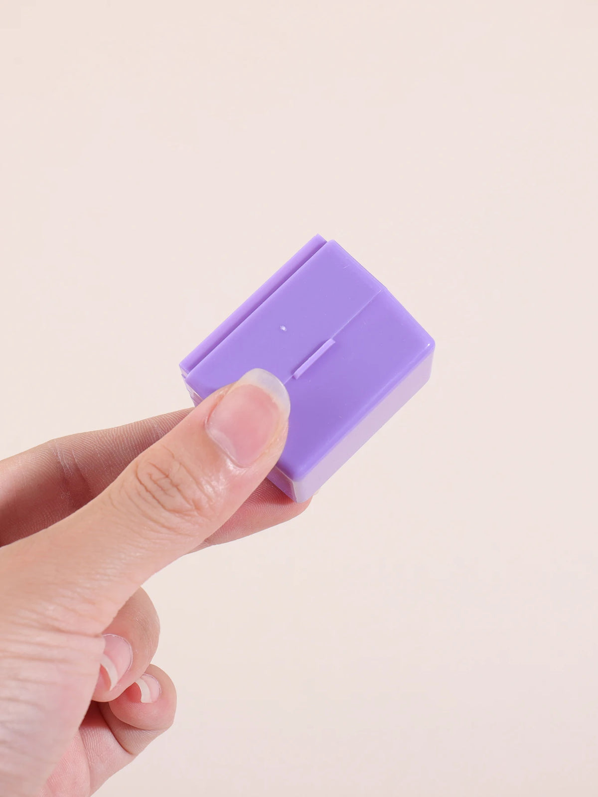 A hand holds a purple privacy protection roller stamp for confidential documents.