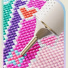 A large suction point drill pen tip for painted diamond paintings shown over colorful mosaic patterns.