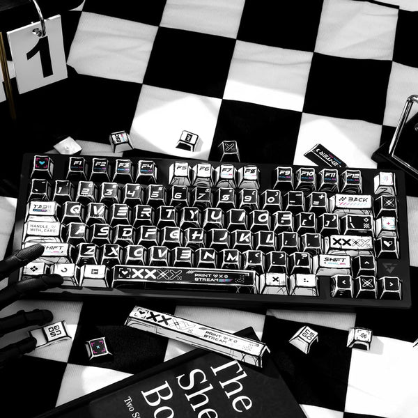 A close-up of a black mechanical keyboard featuring a comic-style PBT keycap set with black and white themes.