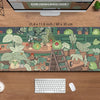 A large green kawaii frog desk mat featuring various potted plants and natural elements.