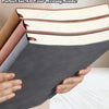 A stack of soft cover notebooks in various colors, including gray and pink, being held by hands.