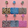 A collection of leopard print retractable card holder clips in various colors and patterns.