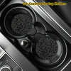 Two non-slip leather coasters with leopard print designs placed in a car cup holder.