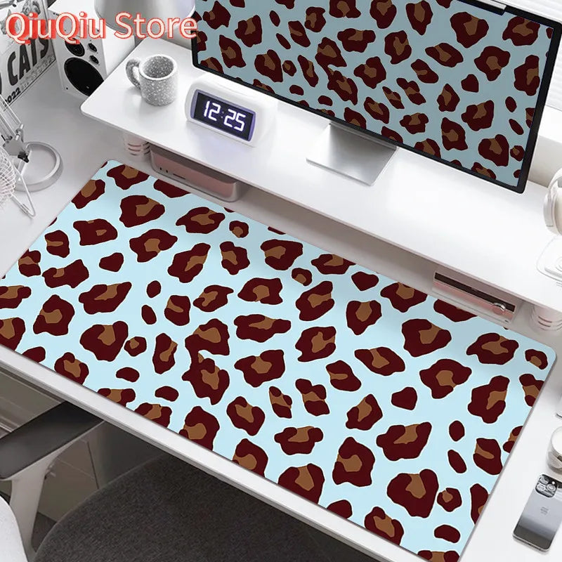 A large desk pad featuring a leopard print design with brown and tan spots on a light blue background.