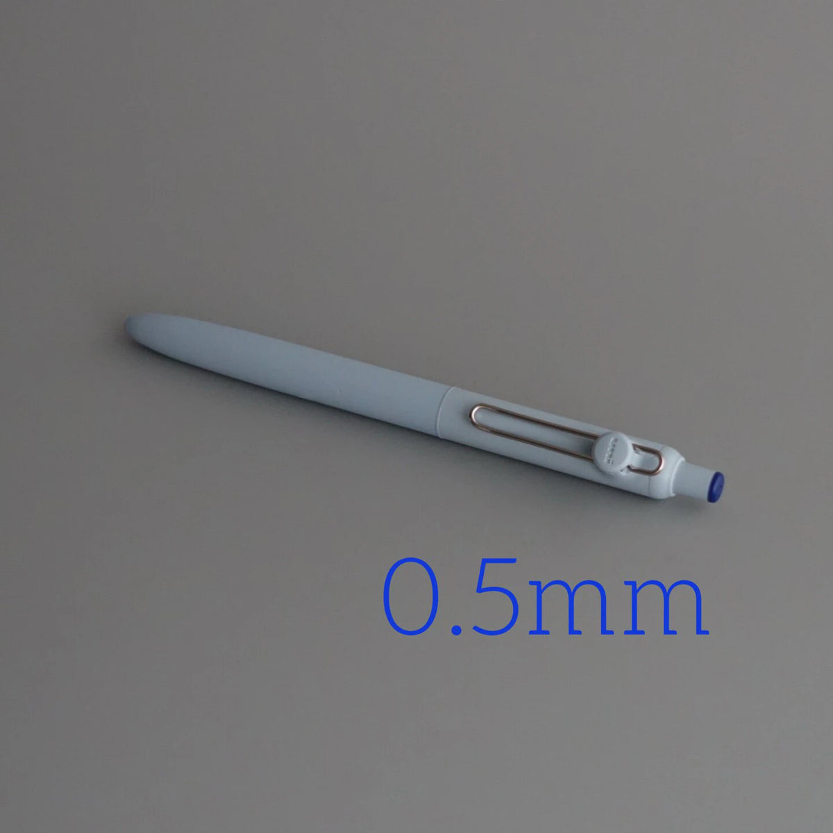 A close-up view of a light gray precision gel pen with a blue tip, labeled as 0.5mm.