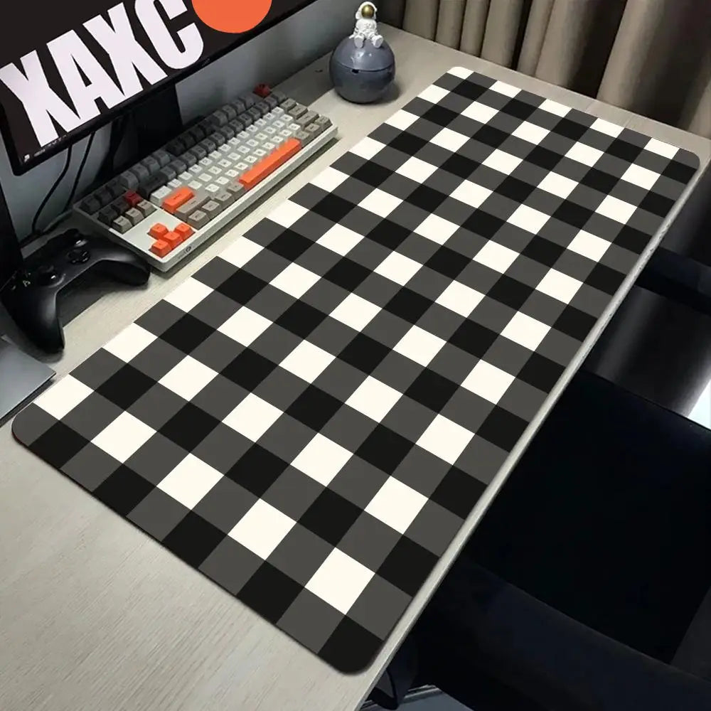 A black and white checkered desk mat is placed on a light-colored desk next to a keyboard.