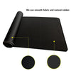 Black gaming mouse pad rolled up, showing smooth fabric and natural rubber texture.