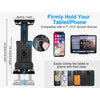 A black adjustable mount for holding tablets and phones, shown with various devices and accessories.