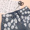 Pair of denim jeans featuring white floral embroidery patterns