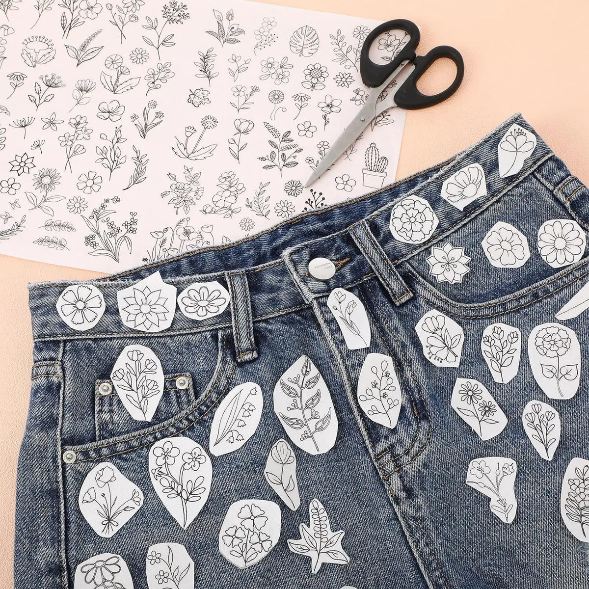 Pair of denim jeans featuring white floral embroidery patterns