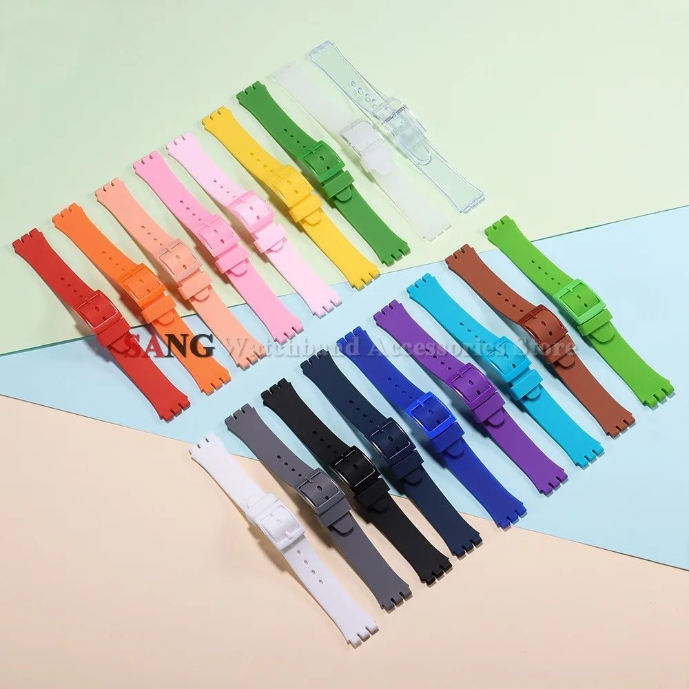 Assortment of colorful silicone watch straps and replacement tools laid out on a light background.
