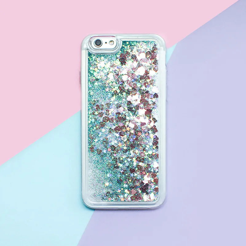 Clear phone case filled with iridescent glitter and holographic particles resting on a pastel background.