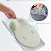A hand is tearing open a beige anti-slip PU base mouse pad, showing its grip and texture.