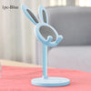 A light blue rabbit-shaped mobile phone stand with a mesh design, shown on a pink surface.