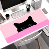 A black cat silhouette design on a pink mouse pad placed on a white desk.