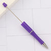 A purple DIY beadable pen with a silver tip resting on a white surface.