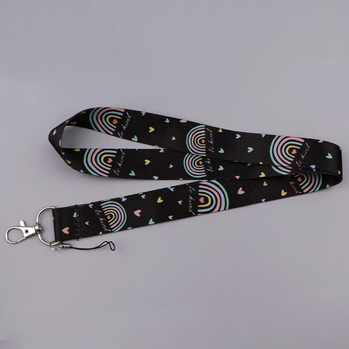 Black fabric lanyard with a rainbow pattern and small hearts for badges and keys