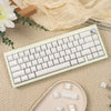 A light green custom printed jelly keycap mechanical keyboard is displayed on a beige textured surface with loose keycaps.