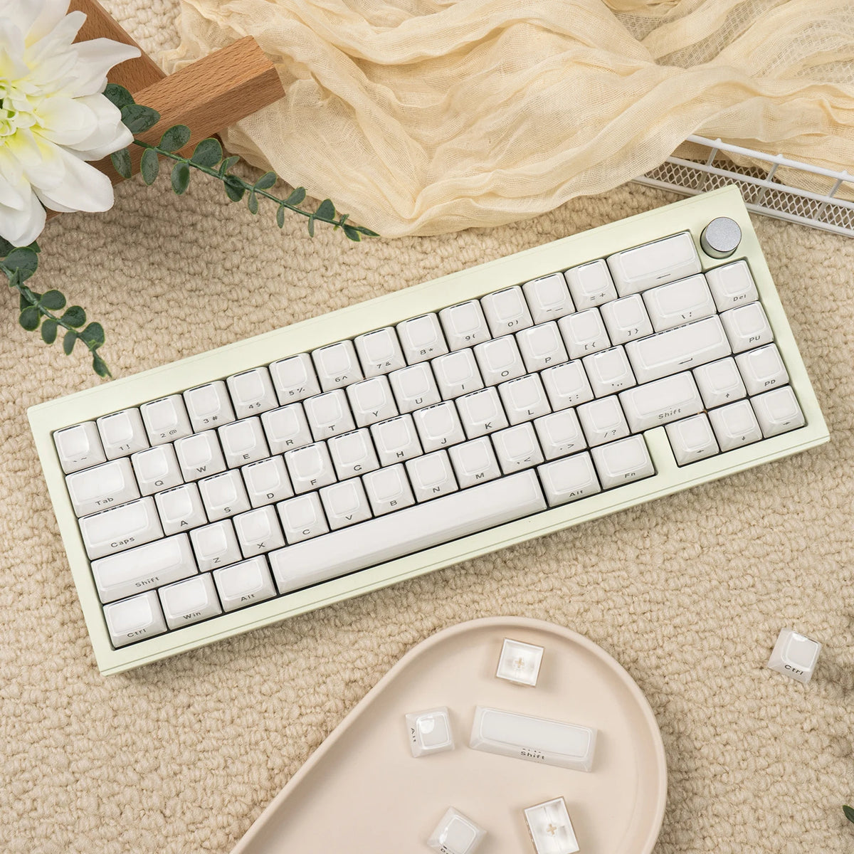 A light green custom printed jelly keycap mechanical keyboard is displayed on a beige textured surface with loose keycaps.