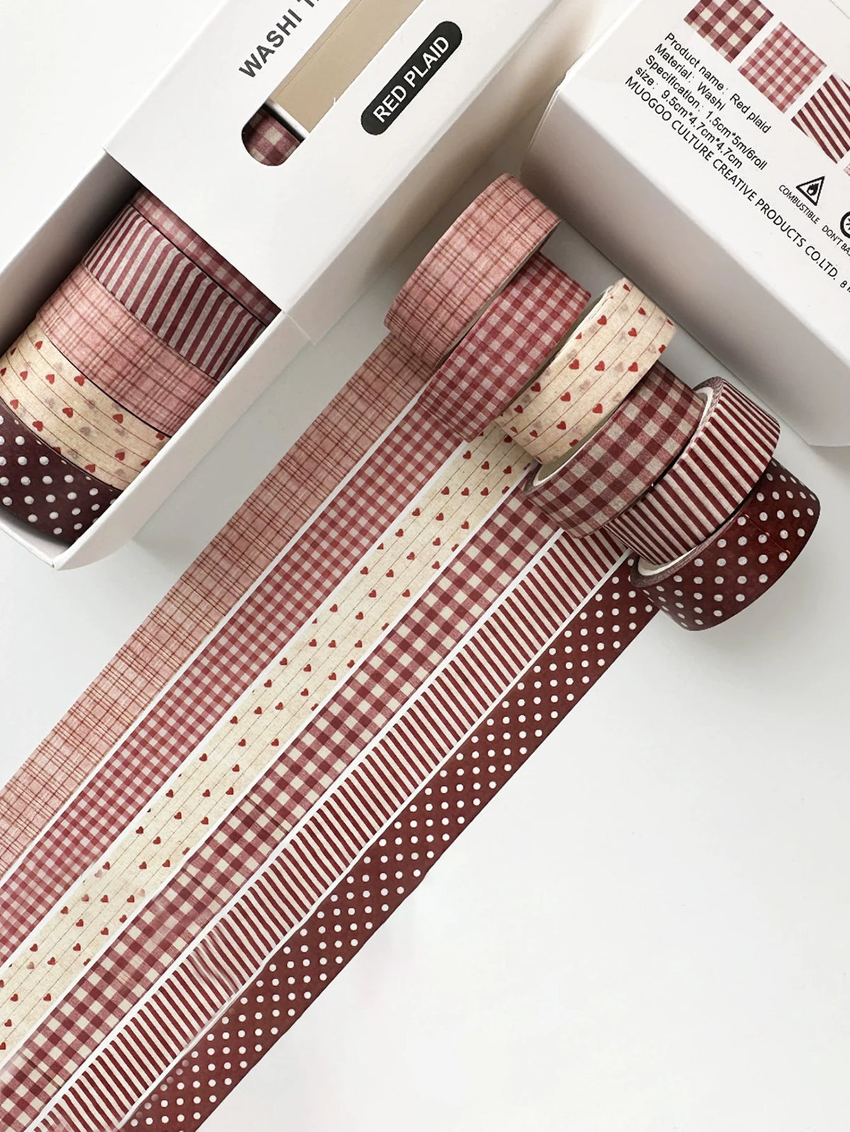 A set of six rolls of red and white plaid and polka dot washi tape for crafting and journaling displayed in its packaging.