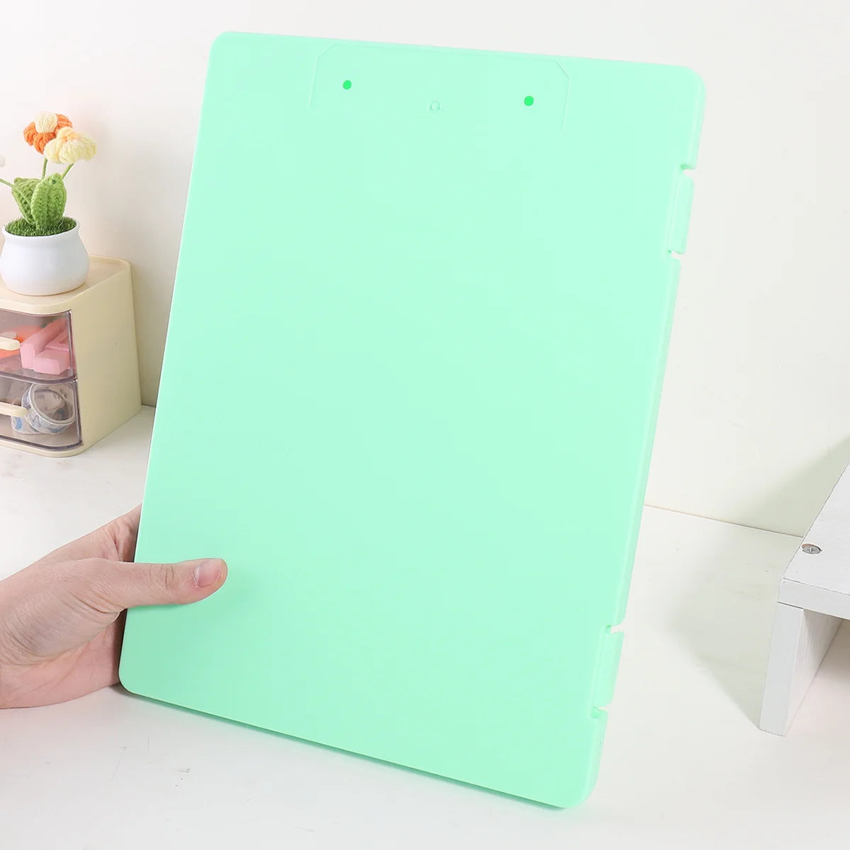 A light green A4 document and photo storage file box is shown on a white surface.
