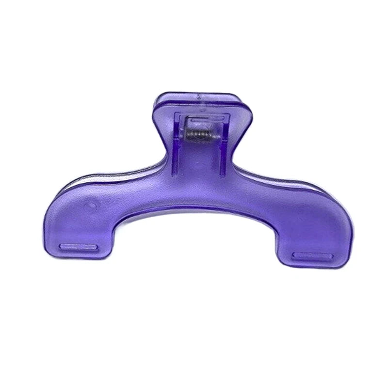 A purple plastic book page clip with a curved shape and a rectangular opening.